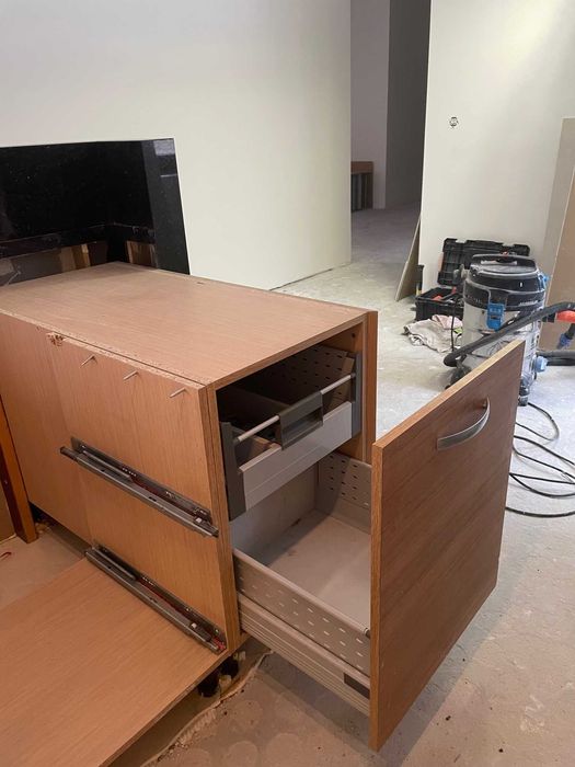 Kuchenna wyspa z zabudową meblową i granitowym murkiem.