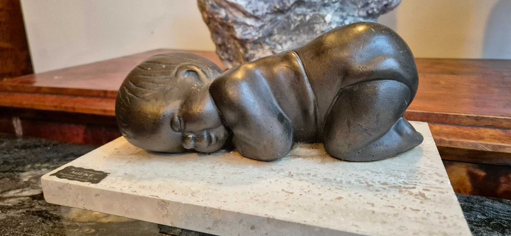 Aukcyjna rzeźba śpiącego dziecka z brązu z ciemną patyną dekor