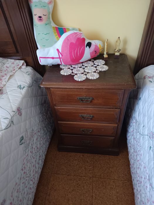 Uma cómoda um armário uma mesa de cabeceira e duas camas
