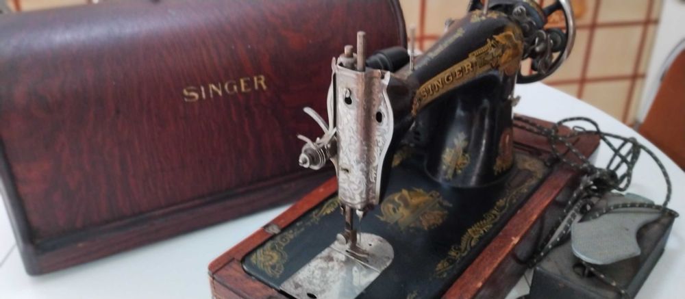 Máquina de costura SINGER elétrica, portátil centenária a funcionar