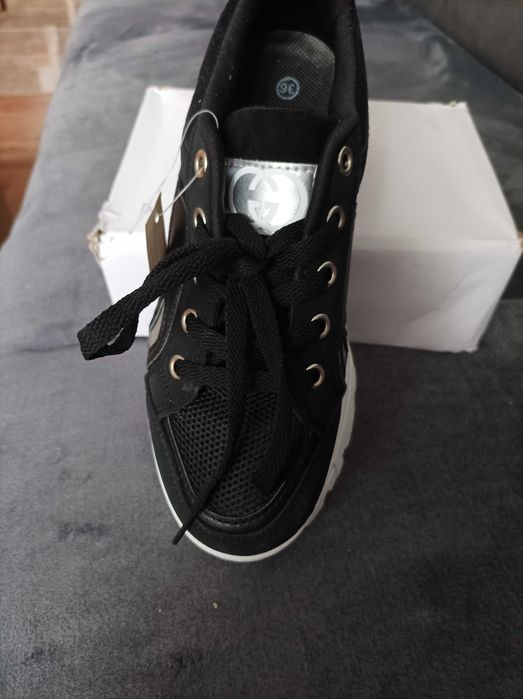 Buty sportowe sneakersy damskie czarne na białej podeszwie.