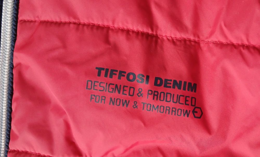 Blusão vermelho Tiffosi. blusão azul e calças de ganga, de crinça.