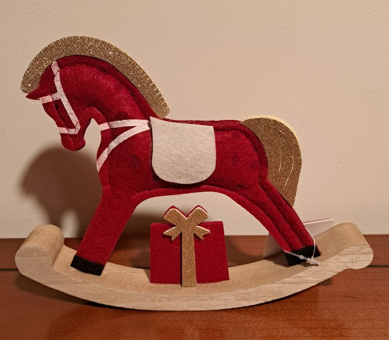 Este é um cavalo de baloiço decorativo de feltro vermelho.