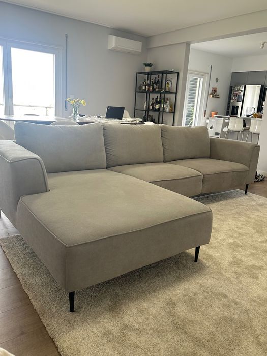 Sofá chaise long cinza com os pés pretos