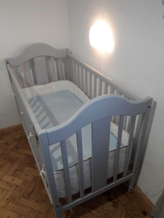 Cama de bebé em cor cinza