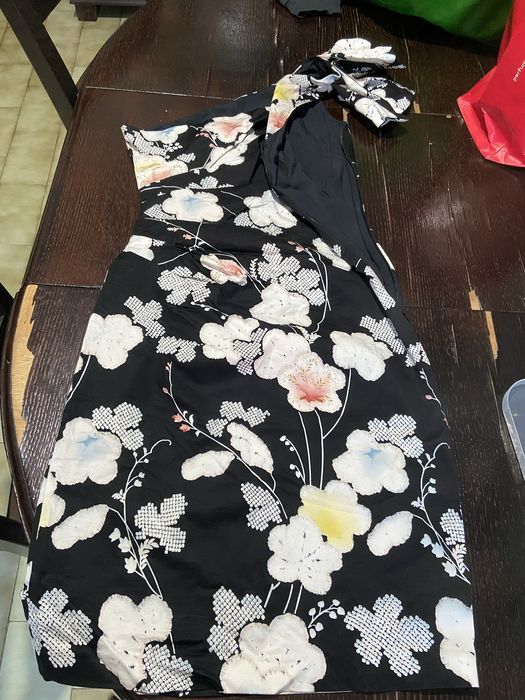 Vestido modelo Oasis Belle uma peça de cocktail com decote de um só onbro e padrão floral sobre fundo preto