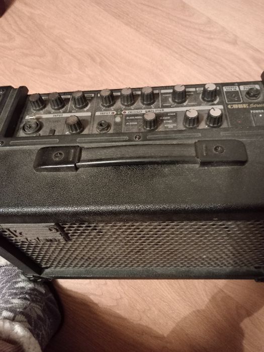 Guitarra eléctrica em caixa com suporte e amplificador