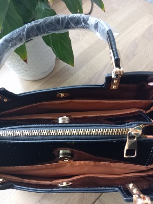 Elegancka torebka z czarnej lakierowanej skóry ze złotymi dodatkami