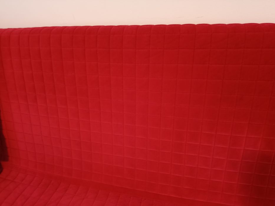 Sofá  cama devermelho aveludado.