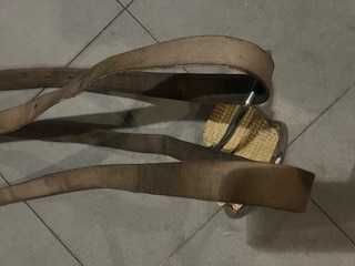 Um par de estribos metálicos com suspensões em couro