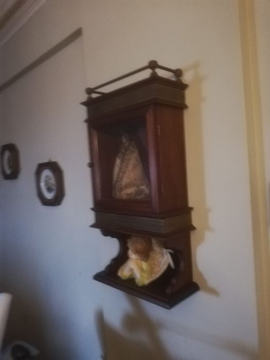 Móvel em madeira, com porta envidraçada.