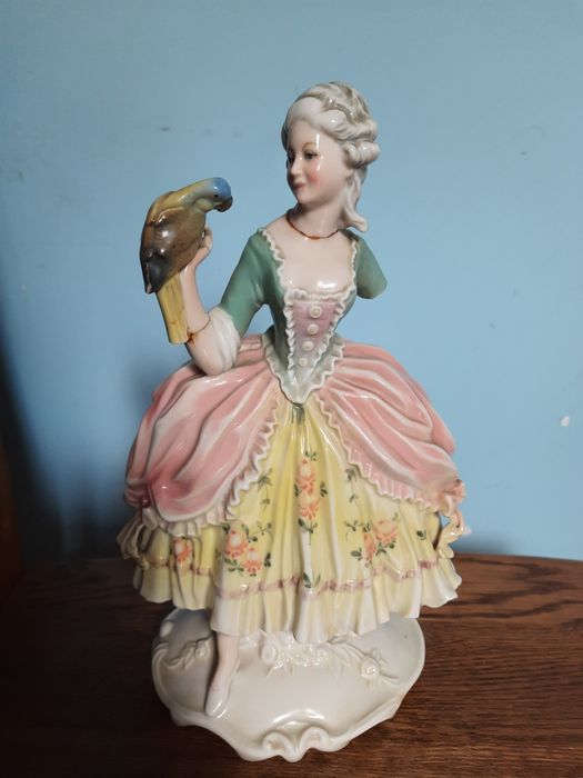 Статуэтка фарфоровая дама с попугаем и цветком.