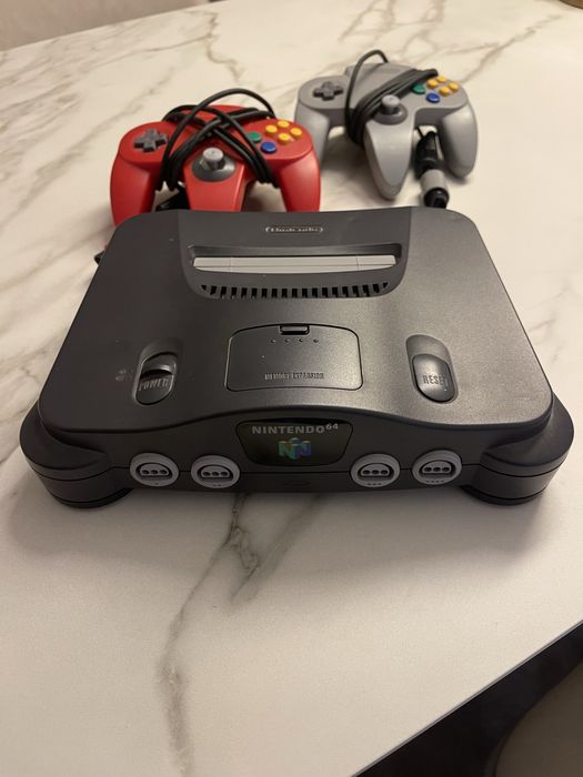 Nintendo 64 com dois comandos + Super Mario 64 e Super Smash Bros