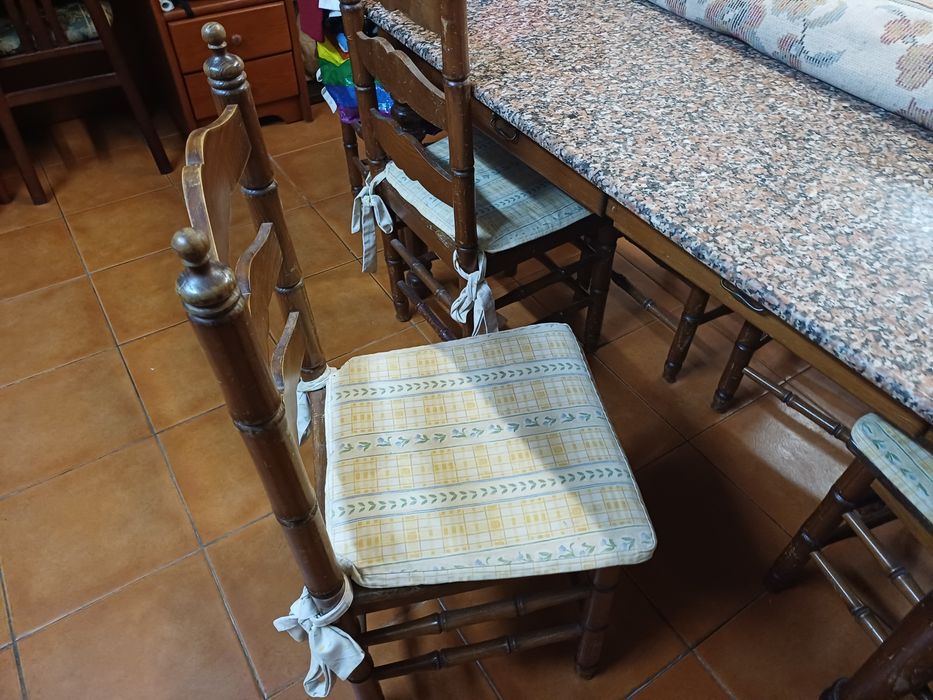 Mesa de cozinha com tampo em pedra, seis cadeiras e suas proteções