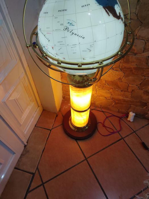 Globo com o mapa do mundo com estrutura em pedra e com base de madeira