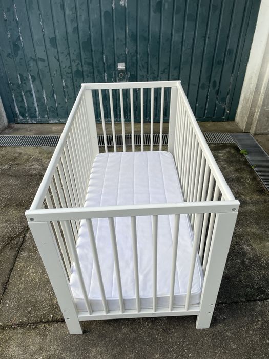 Cama de bebé com colchão.