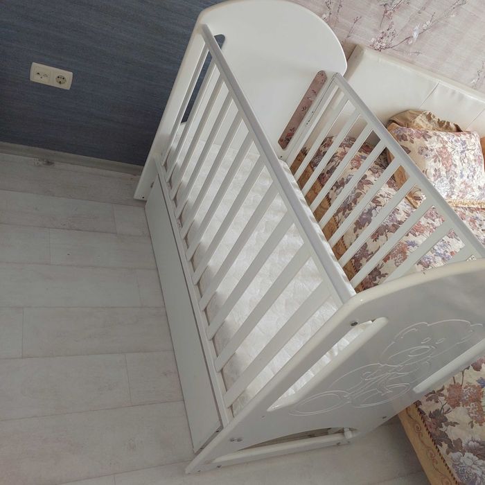 Продам детскую кроватку б/у, белую, с маятником, матрасиком и двумя ящиками .