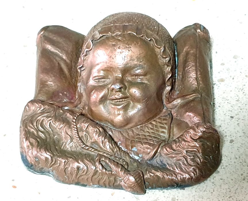 Amorosa antiga escultura de cabeça de um bebé à dormir numa almofada