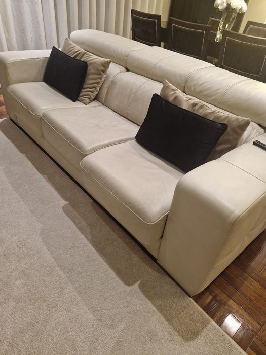 Sofá três lugares em pele beje.