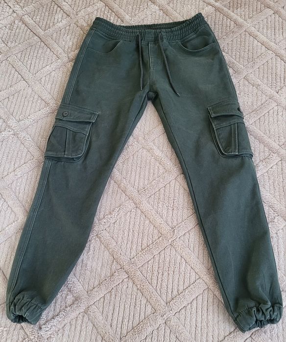 чоловічі штани-карго оливкового кольору з еластичними манжетами внизу.