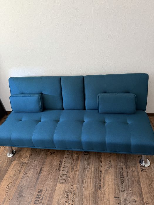 Sofa azul turquesa com base para copos