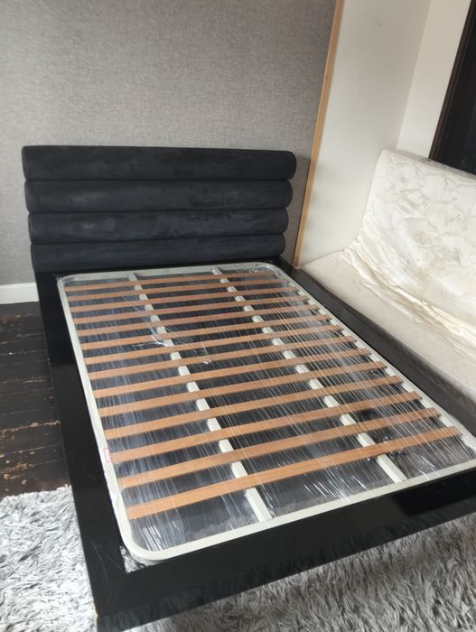 Uma cama casal com estrado e colchão