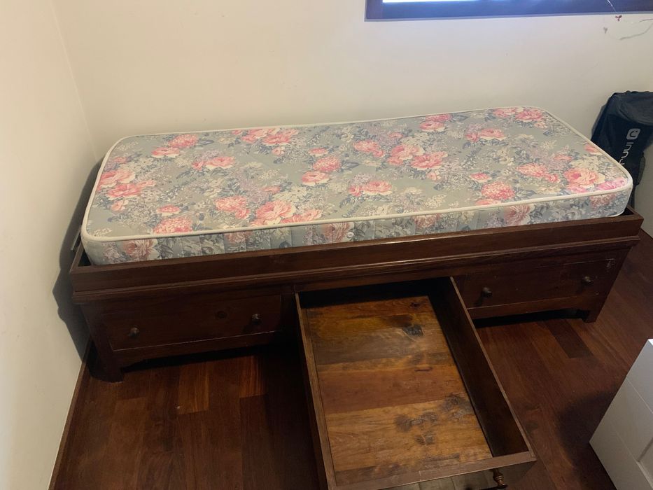 Cama individual e sofá com muita arrumação