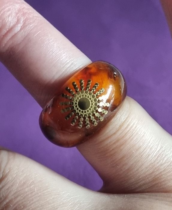 Anel em acrílico castanho com sol dourado, em aço. T17