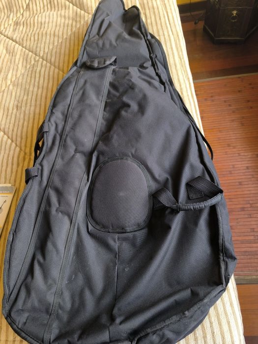 Capa para violoncelo, arco e livros diversos