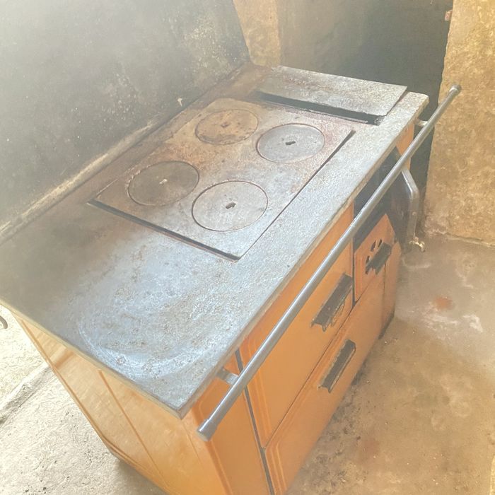 Fogão a lenha vintage degradado para restauro, com torneira agradecido