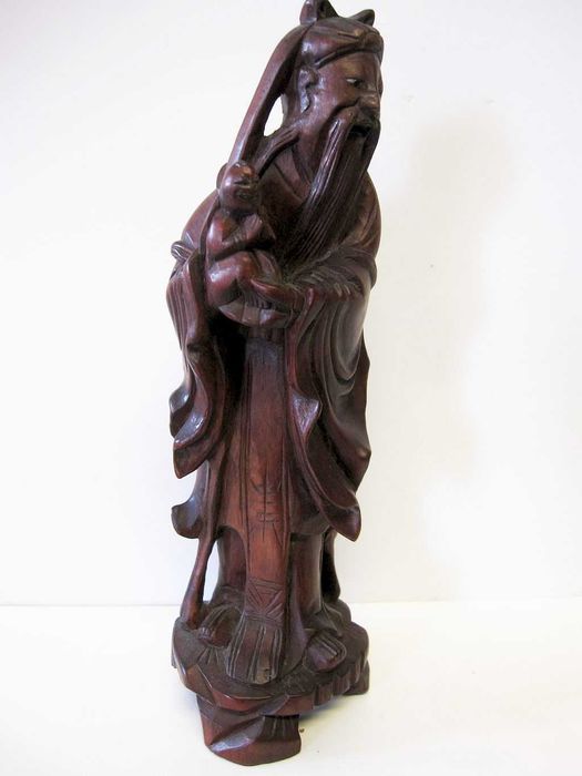 antiga escultura de um sábio asiático esculpido em madeira