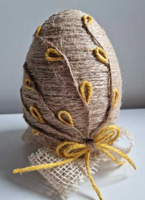 Jajko wielkanocne ręcznie robione z juty na dekoracyjnym stojaku