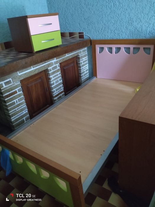 Três camas de solteiro coloridas, mesinha de cabeceira e cómoda