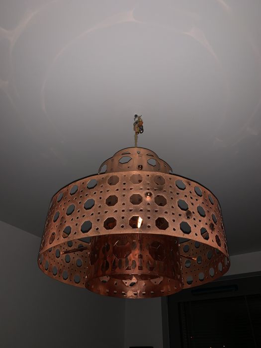 Lampa sufitowa, wiszaca w kolorze miedzianym.