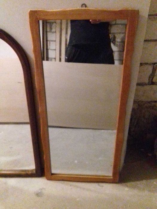 Lustra ścienne w drewnianych ramach.