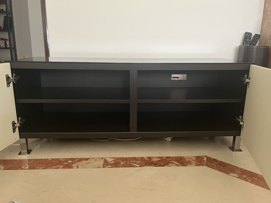 Móvel TV baixo, com duas portas, tampo em vidro escuro e 4 compartimentos arrumação