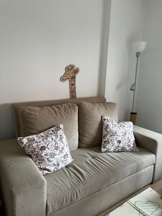 Sofá cama de dois lugares com marcas de uso