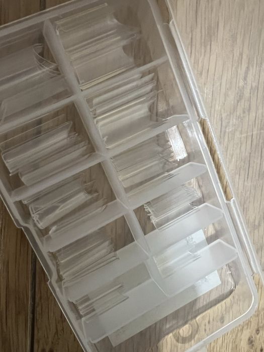 Caixas variadas de tips unhas de gel e almofada de apoio