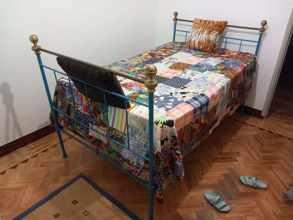 Cama de  ferro em tons de azul.