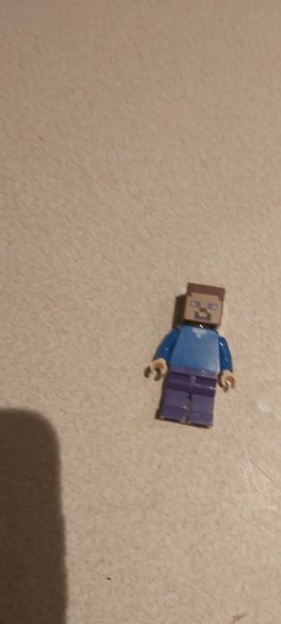 Klocki lego Minecraft Steve z kilofem, zbroją oraz pochodnią.