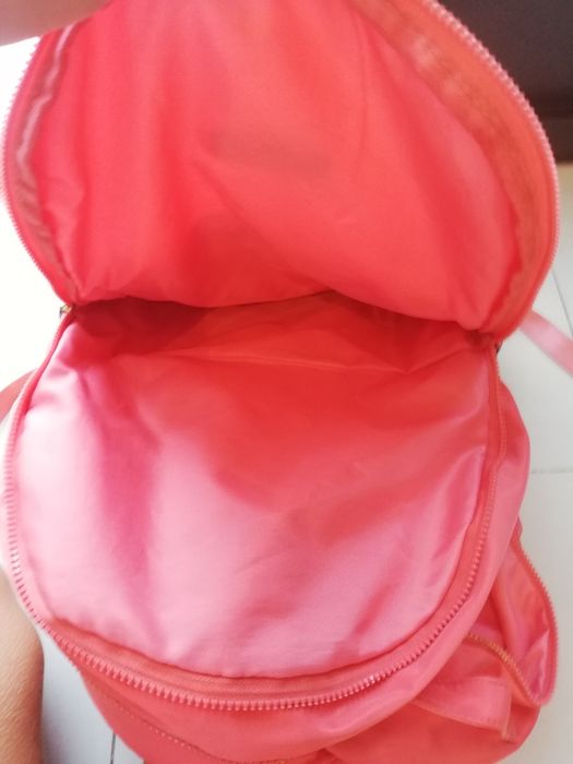 Mochila escolar de cor salmão, com vários compartimentos