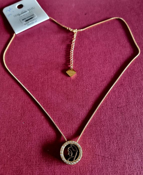 Colar dourado, em aço, com pingente da Nossa Senhora rodeada de zirconias.
