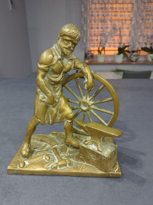 Stara figura kowala w kuźni z brązu.