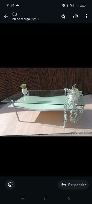 Sofá de três lugares e mesa de centro em vidro