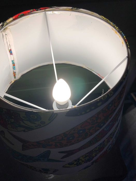 Candeeiro de mesa com base preta e abajur com tecido de sardinhas.