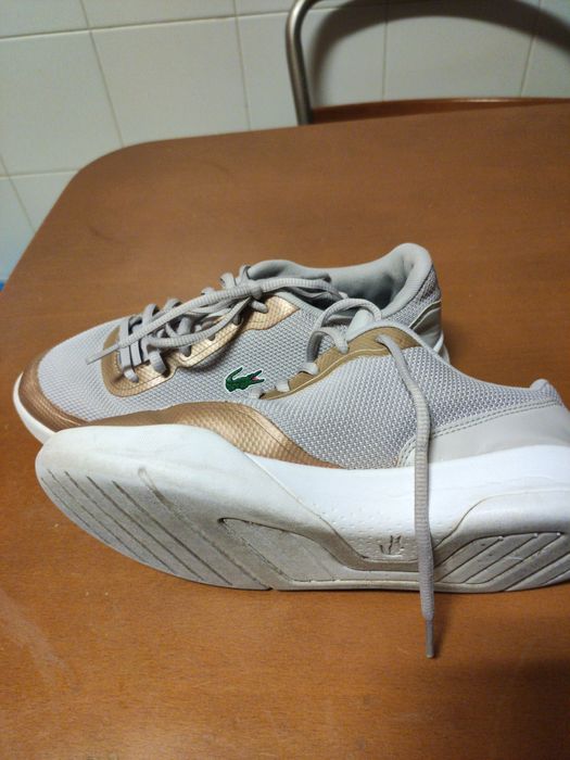 Ténis femininos,marca Lacoste. Cor bege e dourado