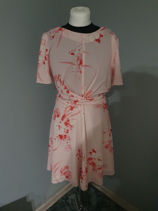 Różowa sukienka w kwiaty wiązana w pasie