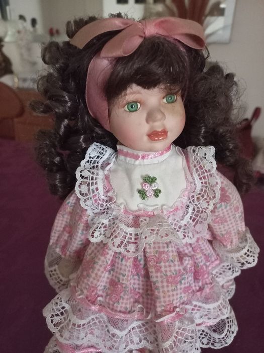 Linda boneca com o rosto em porcelana