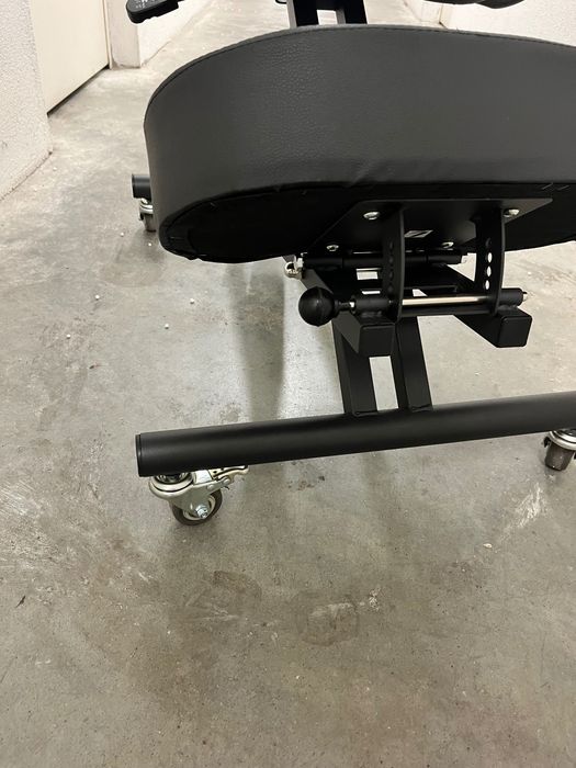 Cadeira ergonómica preta com apoio para costas e joelhos