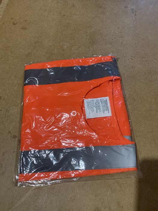 Жилет захисний оранжевого кольору.